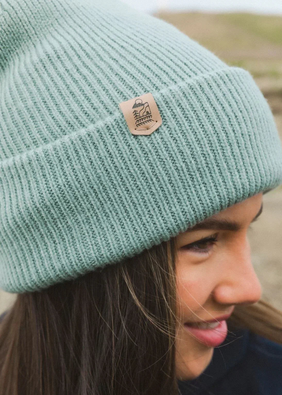 Mint green ribbed beanie with nature patch, eco-friendly adventure apparel for outdoor lovers