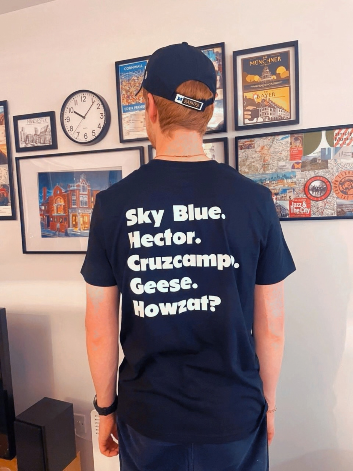 A man viewed from behind wearing a navy blue t-shirt with bold white text reading 'Sky Blue. Hector.