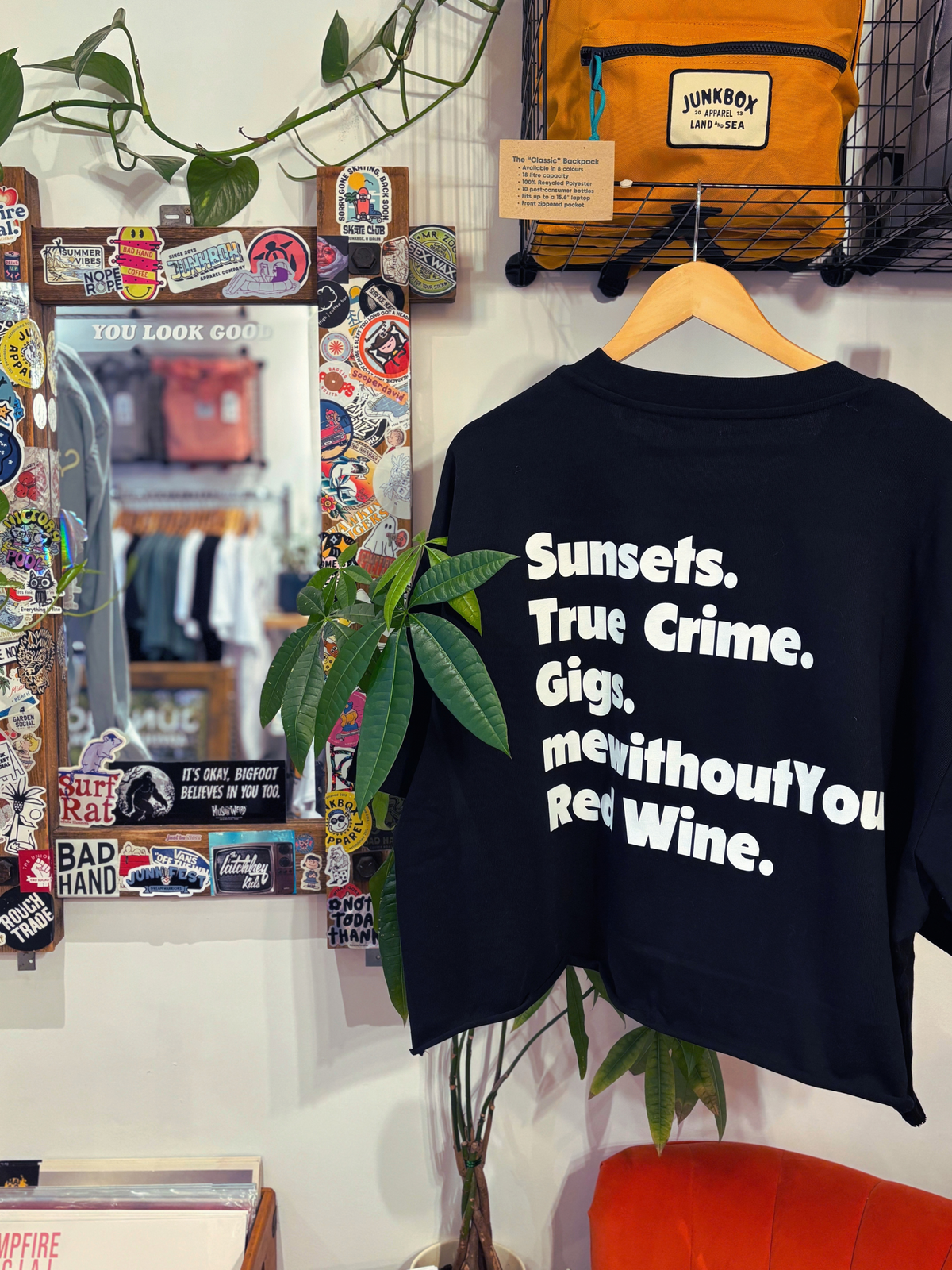 A black graphic t-shirt with bold white text reading 'Sunsets. True Crime.