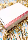 Red box with snowflake pattern on a bed of gold tinsel