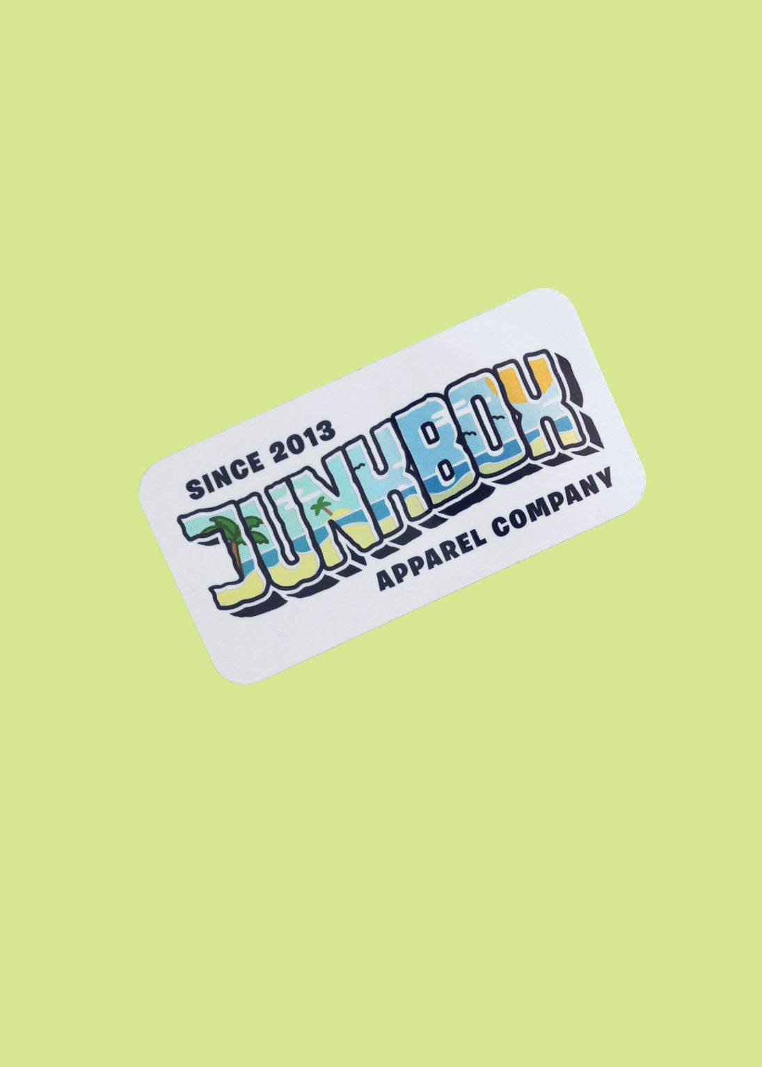 Holographic Sticker with 'Junkbox Apparel Company' text on a light green background